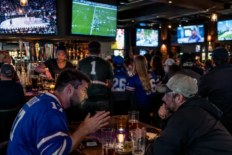 Analyst studies a football schedule board with team names and dates